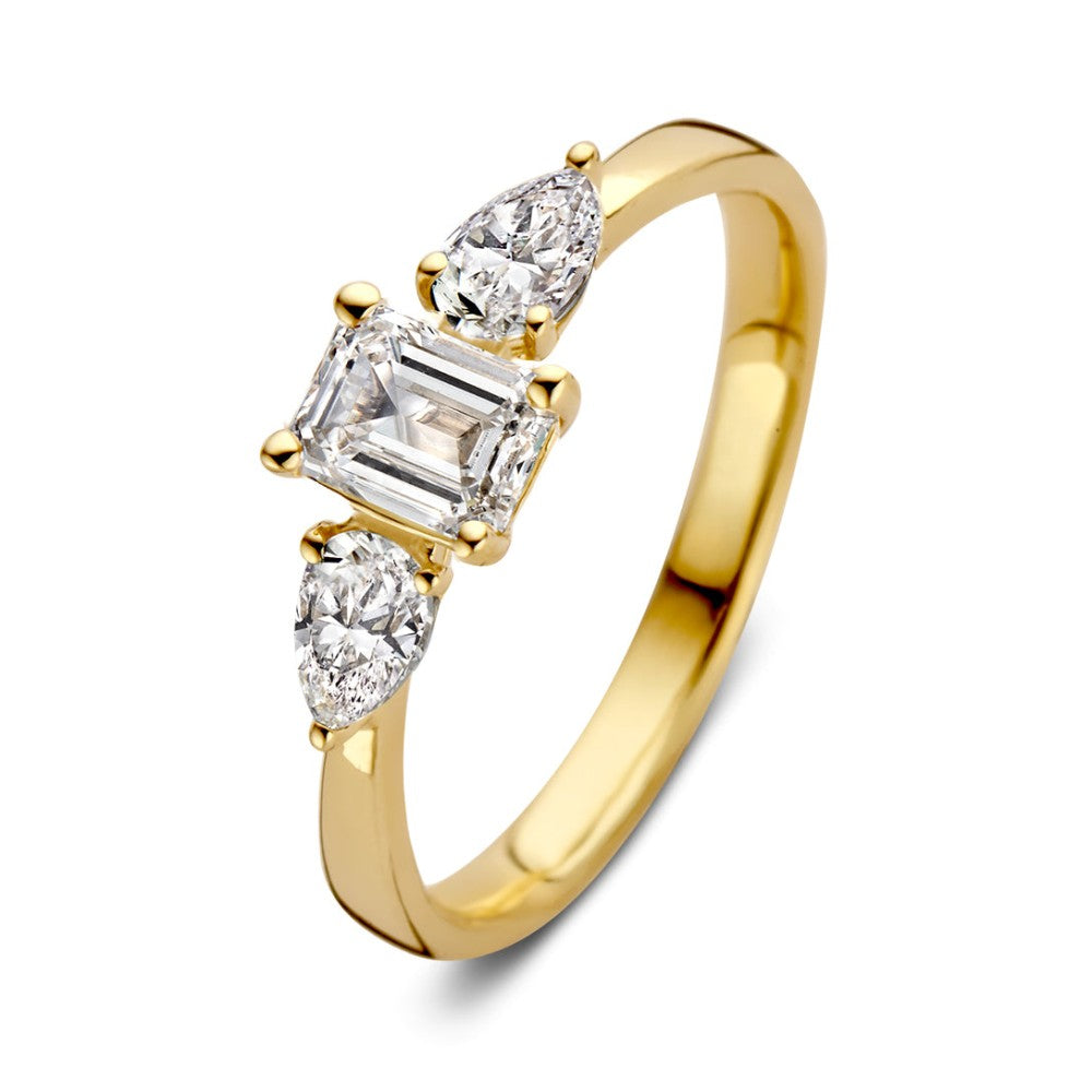 Anillo de oro amarillo con tres diamantes, uno central en forma de esmeralda y dos en forma de pera.