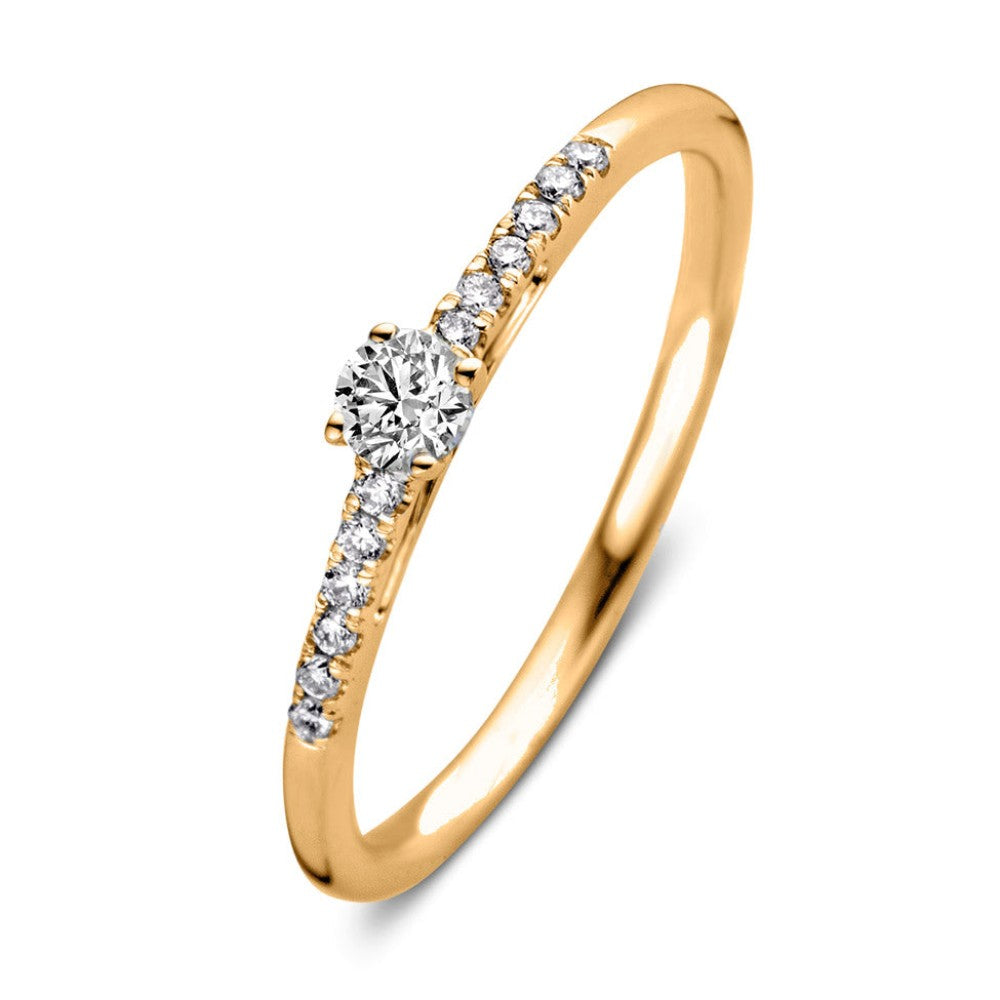 Anillo de oro amarillo con un diamante central y piedras brillantes a los lados.