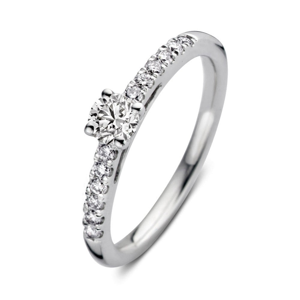 Anillo de oro blanco con diamante central y brillantes en el aro.