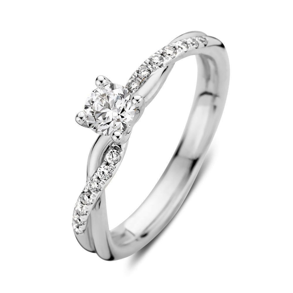 Anillo de oro blanco con diamantes, diseño en espiral y piedra central brillante.