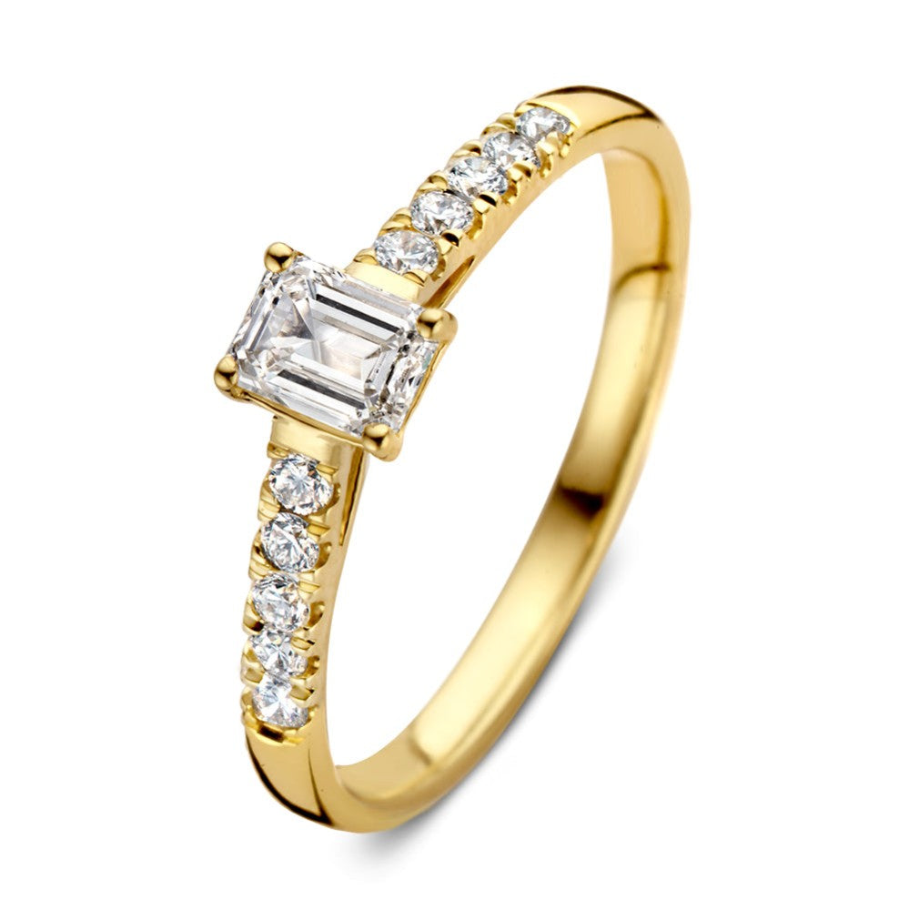 Anillo de oro amarillo con un diamante central rectangular y diamantes brillantes a los lados.
