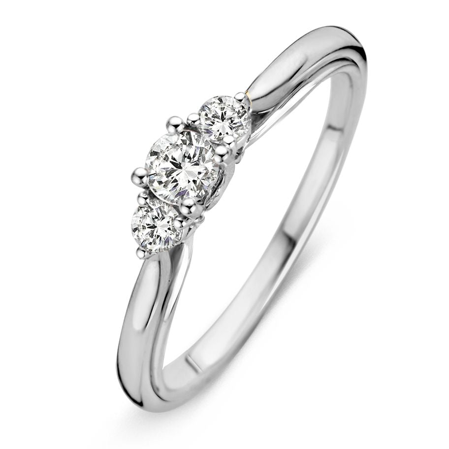 Anillo de oro blanco con tres diamantes, el central de 0.31 crt, diseño estilizado.