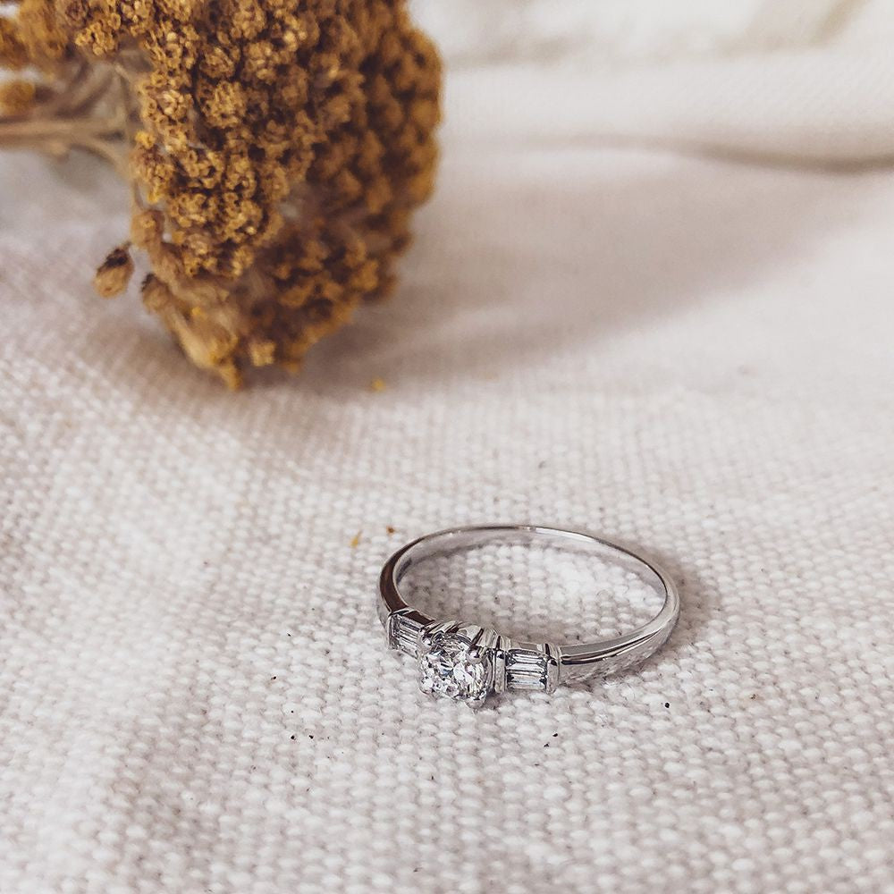 Anillo de oro blanco elegante con centro de corte brillante y piedras laterales baguette