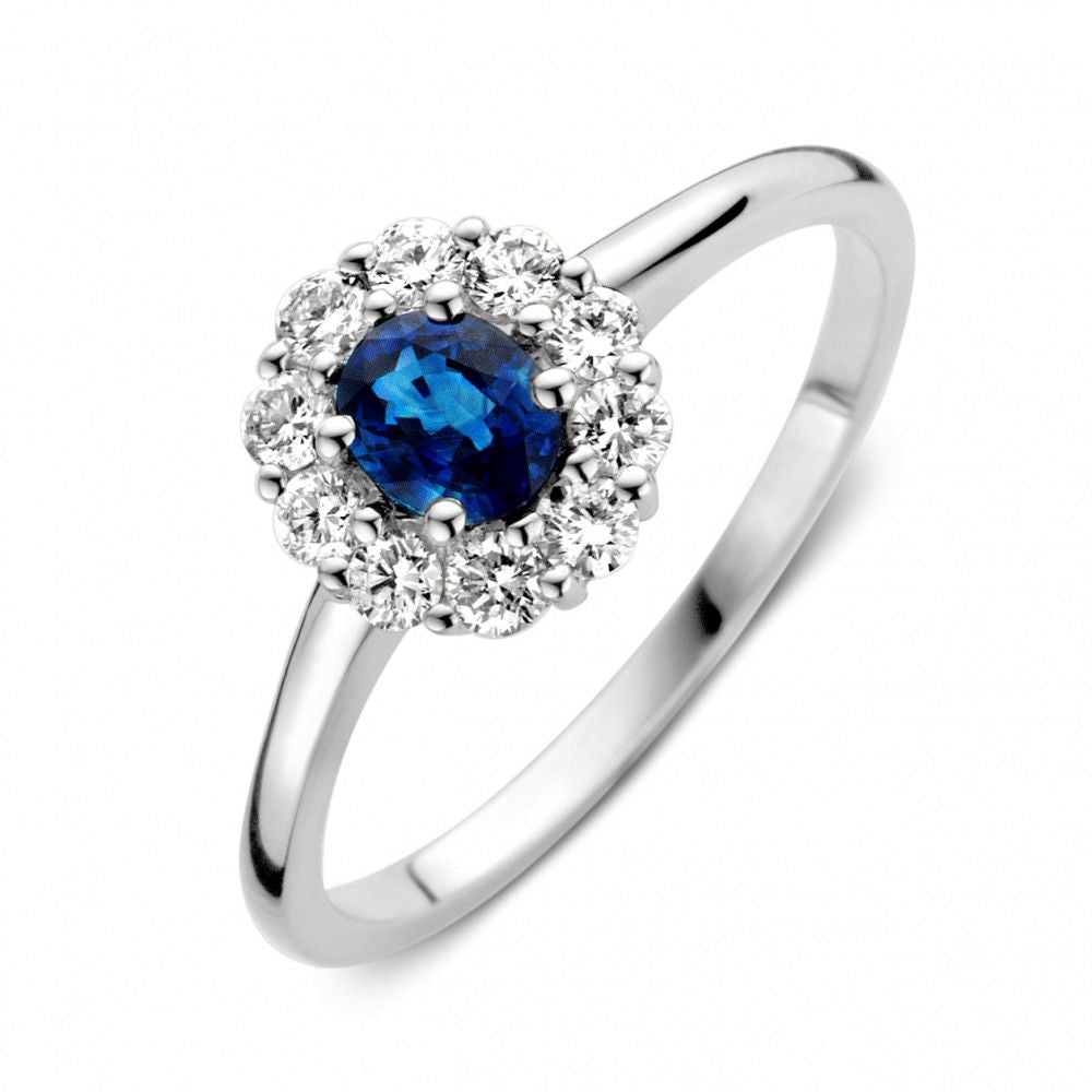 Anillo de oro blanco con zafiro azul y diamantes, con un diseño floral y brillante.