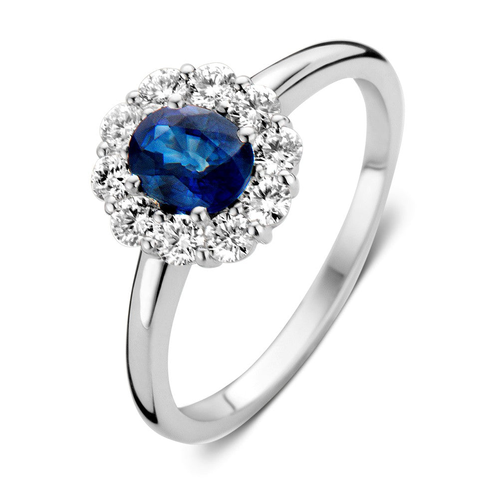 Anillo de oro blanco con zafiro azul y diamantes, con un diseño clásico y elegante.