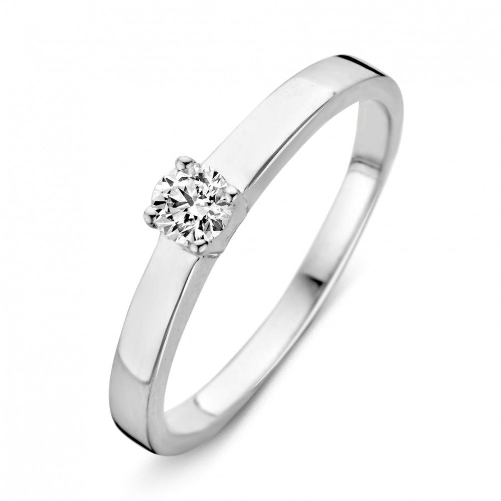 Anillo de oro blanco brillante con circonitas, diseño sencillo y elegante, con una piedra central.