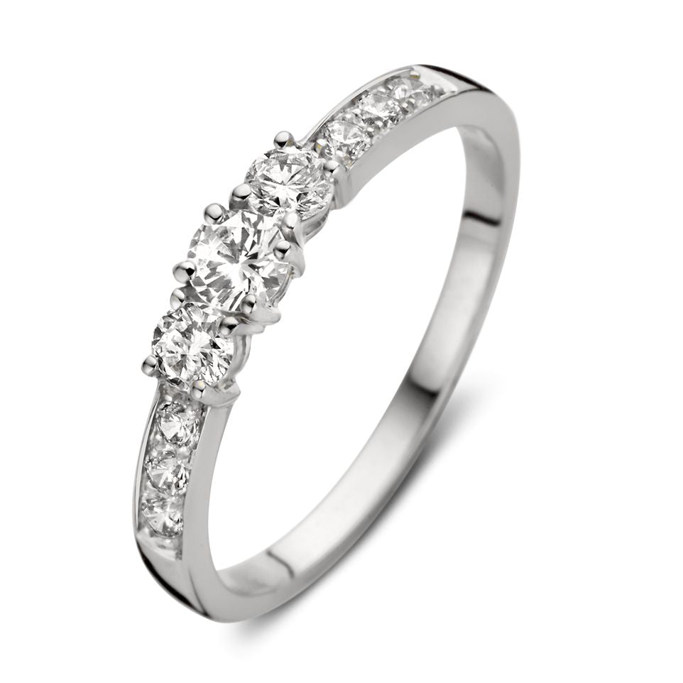 Anillo de oro blanco con circonitas, diseño delicado y brillante, con tres piedras centrales.
