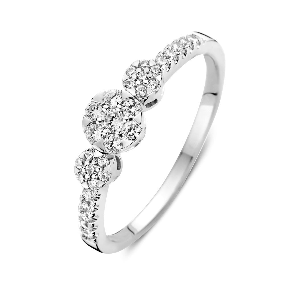 Anillo de oro blanco con tres piedras de circonita y piedras laterales brillantes.