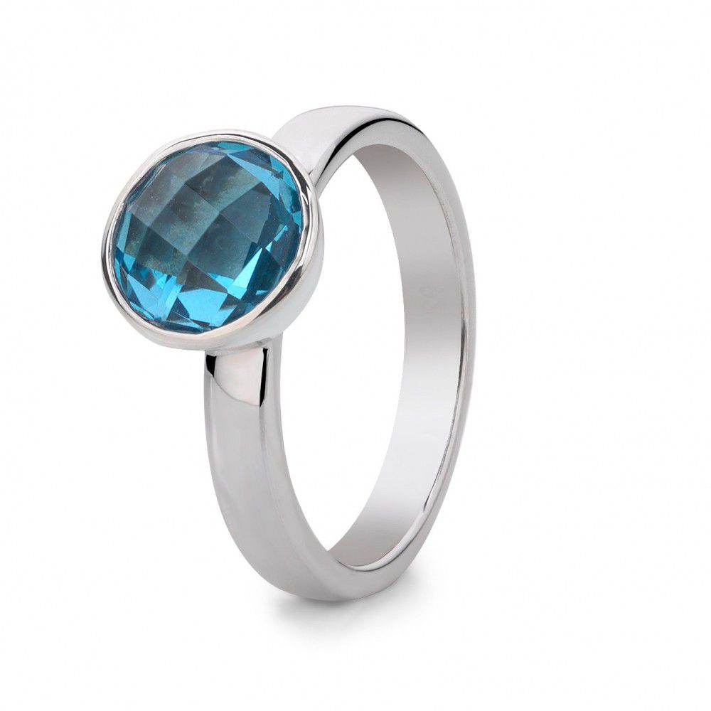 Anillo de plata rodiada para dama con topacio azul facetado y diseño moderno.