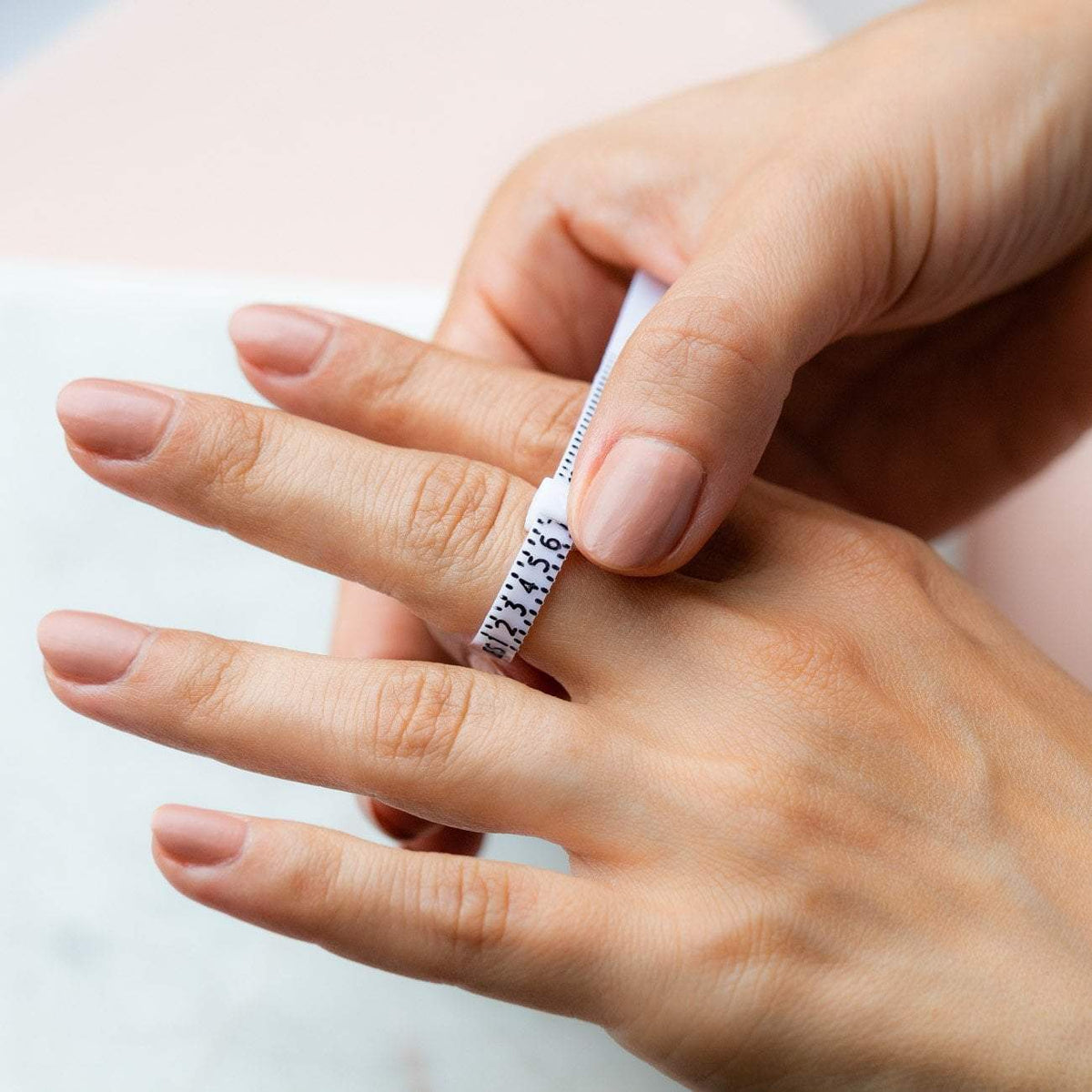 Anillo medidor blanco con escala para determinar la talla perfecta.