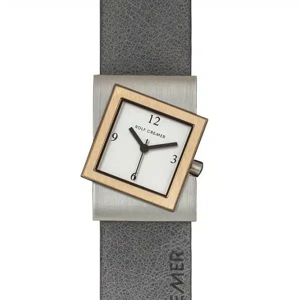 Reloj cuadrado con caja plateada y dorada, esfera blanca y correa de cuero gris.