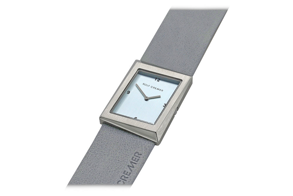 Reloj cuadrado con esfera azul claro y correa gris de cuero.