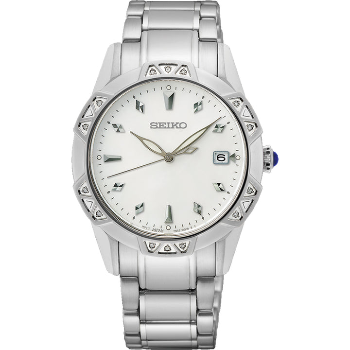 Het Seiko dameshorloge SKK727P1 heeft een zilveren metallic afwerking, een ronde witte wijzerplaat, zilveren uurmarkeringen en een datumvenster op 3 uur. Het beschikt over een gegraveerde driehoekige lunette, waterdichtheid 10ATM, quartz uurwerk en metalen schakelband.