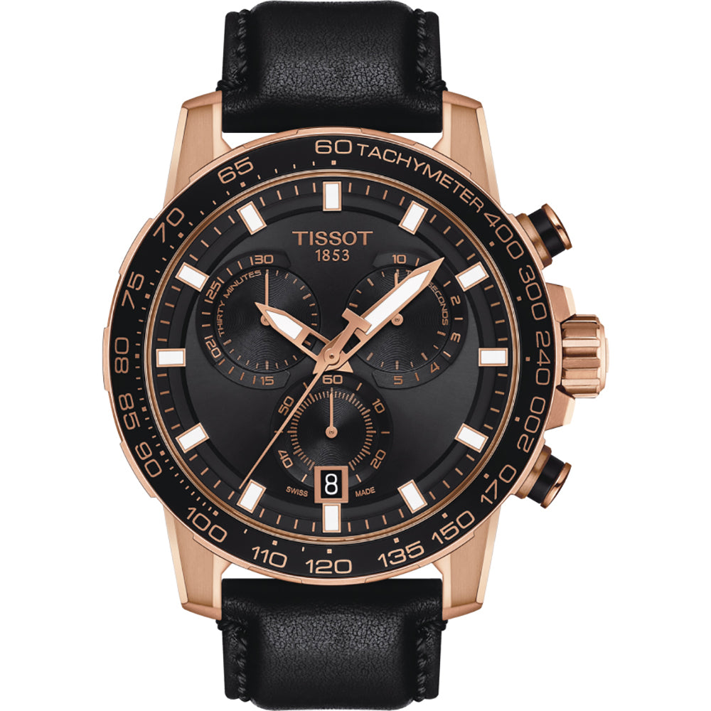 Reloj cronógrafo Tissot con esfera negra, detalles en rosa dorado y correa de cuero negra.