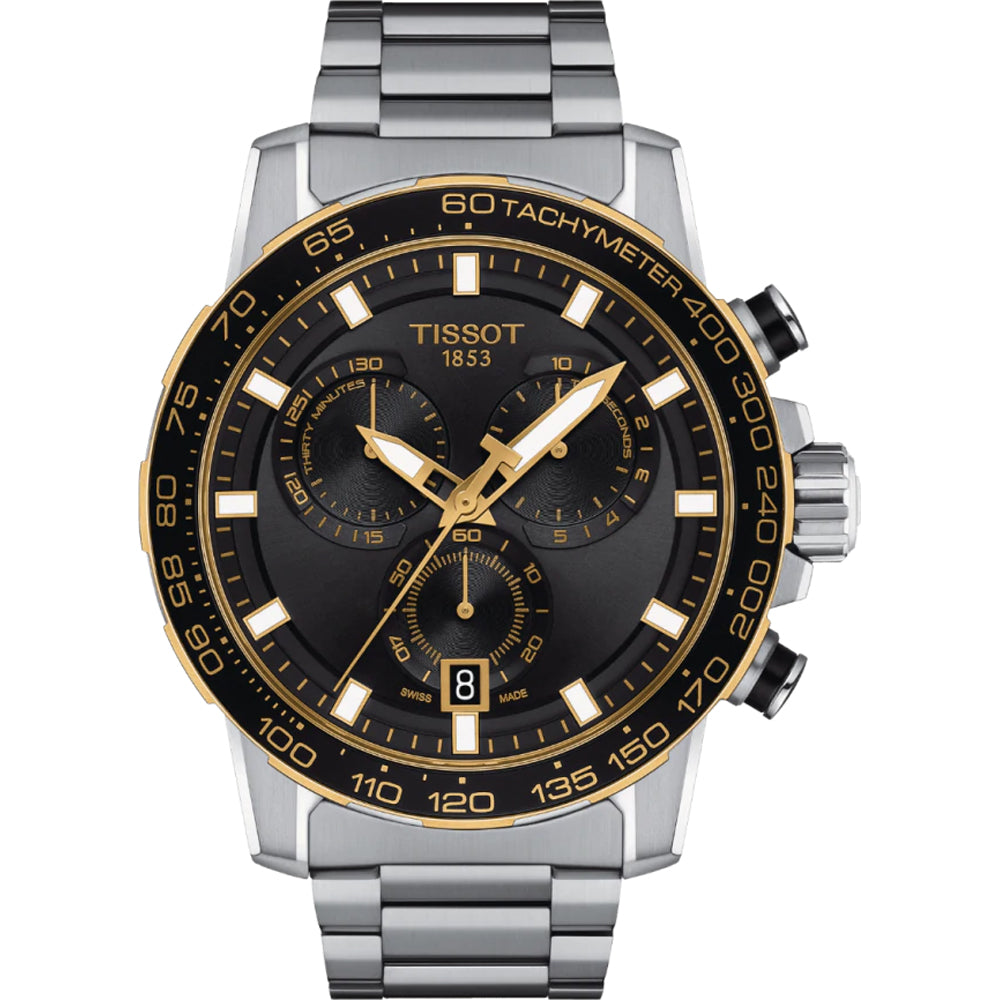 Reloj cronógrafo Tissot con esfera negra, detalles dorados y correa de acero inoxidable.