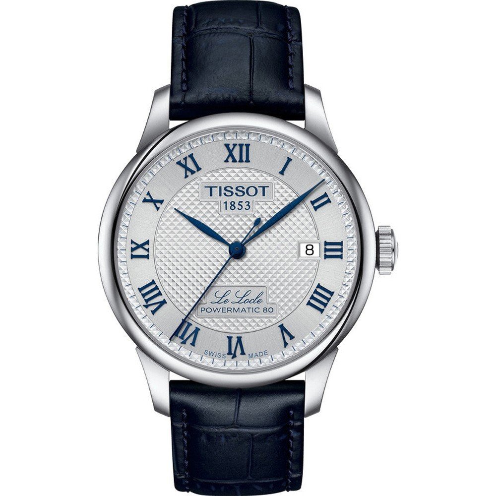 Reloj Tissot Le Locle con esfera plateada, números romanos, correa de piel azul y caja de acero inoxidable.