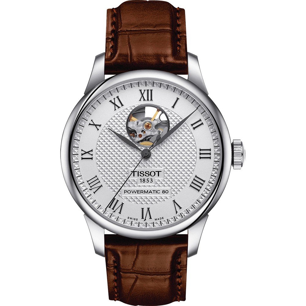 Reloj Tissot con esfera plateada, correa de cuero marrón y apertura en el centro.