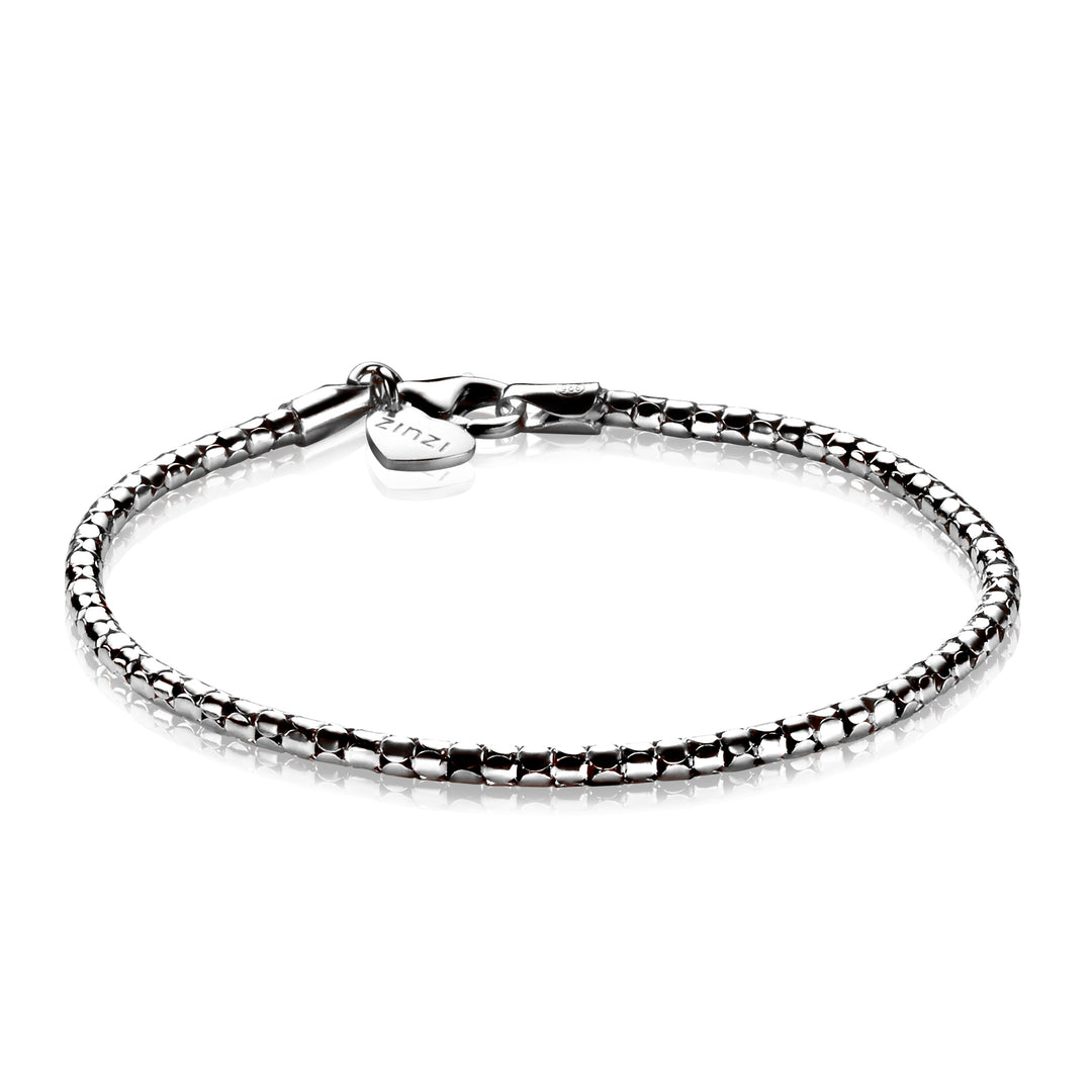 De Zinzi Armband Zilver Zia1129 A is een glanzende zilveren armband met slangenketting, een karabijnsluiting en een klein rond label bij de sluiting, waardoor het licht op elegante wijze wordt weerkaatst op het elegante zilverkleurige uiterlijk.