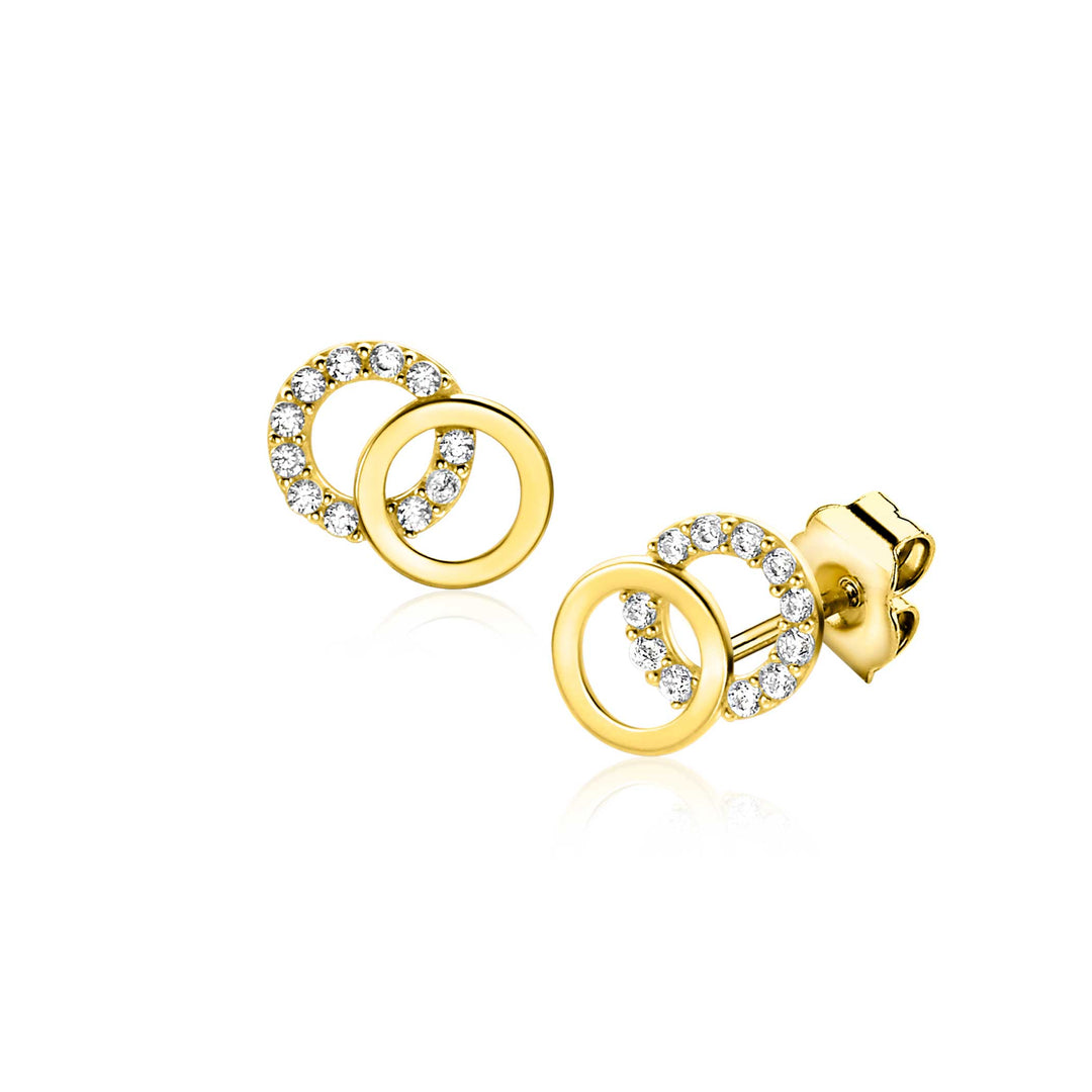 De Zinzi Oorbellen Goud Zgo466 heeft twee in elkaar grijpende cirkels, één in effen goud en de andere versierd met witte zirkonias. Met een push-back sluiting en een reflecterende afwerking bieden deze oorbellen elegantie en verfijning.