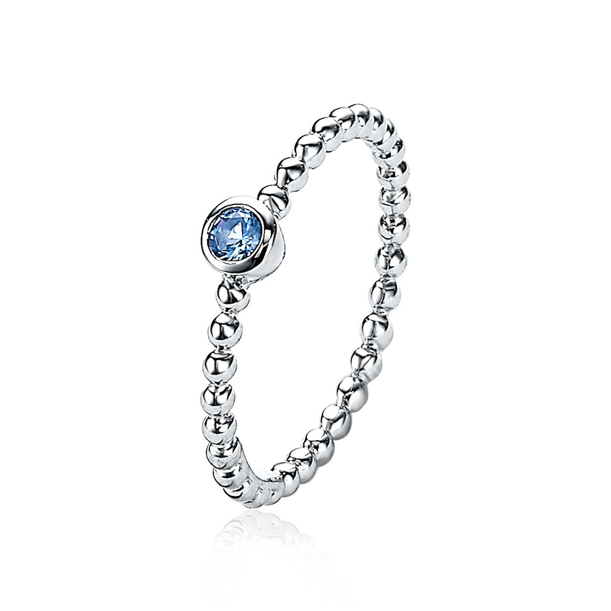 Anillo de plata con un diseño de bolitas y una piedra azul en el centro.