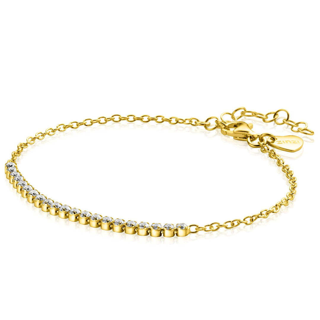 De Zinzi Armband Gold Plated Zia2370 Y is een delicate armband versierd met sprankelende zirkonia stenen aan één kant. Het bevat een verstelbare sluiting, verlengkettingen en een kleine ronde bedel.