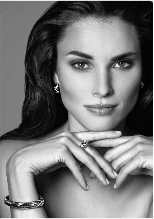 Pendientes de plata con diseño elegante, llevados por una modelo con cabello oscuro.