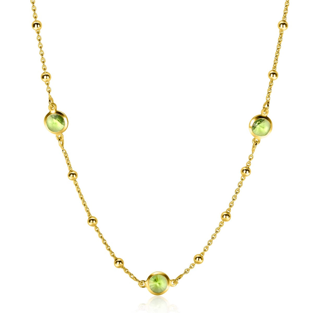 Collar dorado con esferas y tres piedras verdes engastadas.
