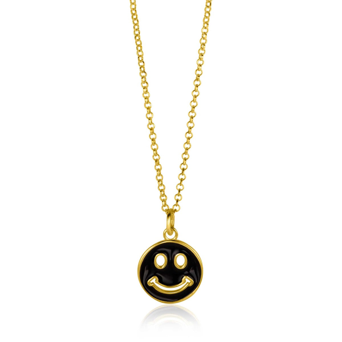 Colgante dorado con cara sonriente sobre fondo negro, suspendido de una cadena delicada.